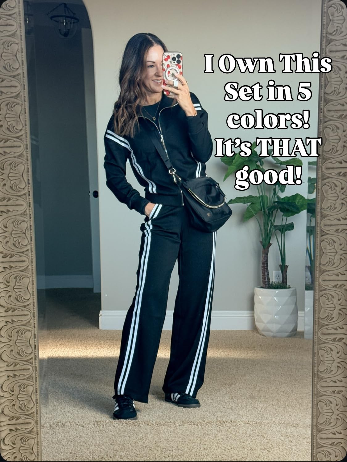 Holly wearing a black athletic matching set with white stripes, featuring a zip-up jacket and wide-leg pants.