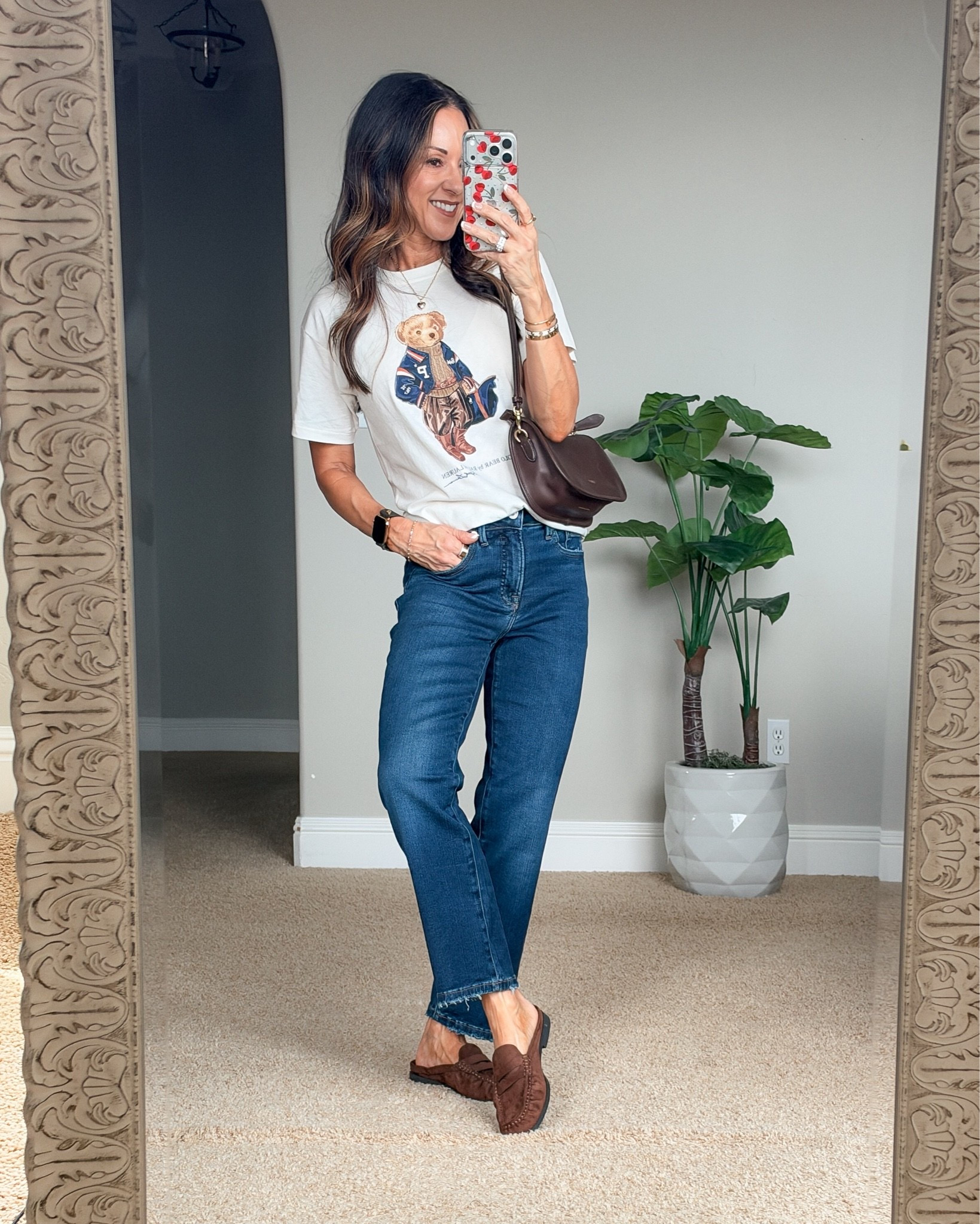 Holly styling blue Good American jeans with a white graphic T-shirt and brown loafers for a casual everyday outfit.