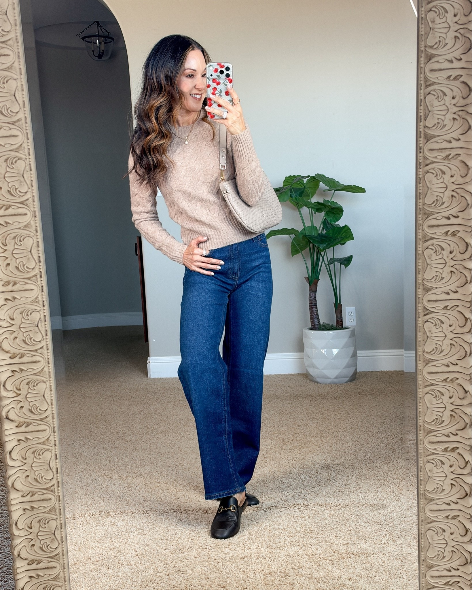 Holly wearing Quince straight-leg jeans in a medium blue wash with a neutral cashmere sweater and black shoes, showcasing a petite-friendly fit.